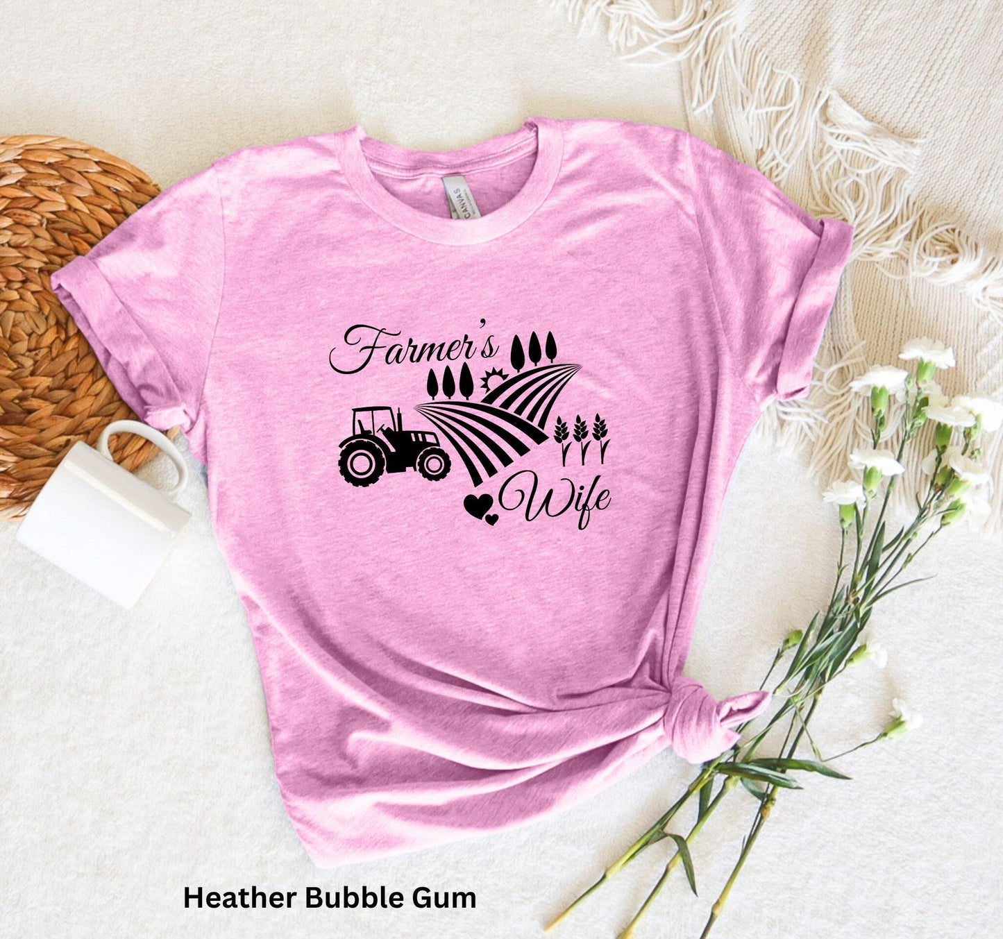 Farmer’s Wife light pink t-shirt with tractor, wheat field and heart design, celebrating country living and hardworking farm women.