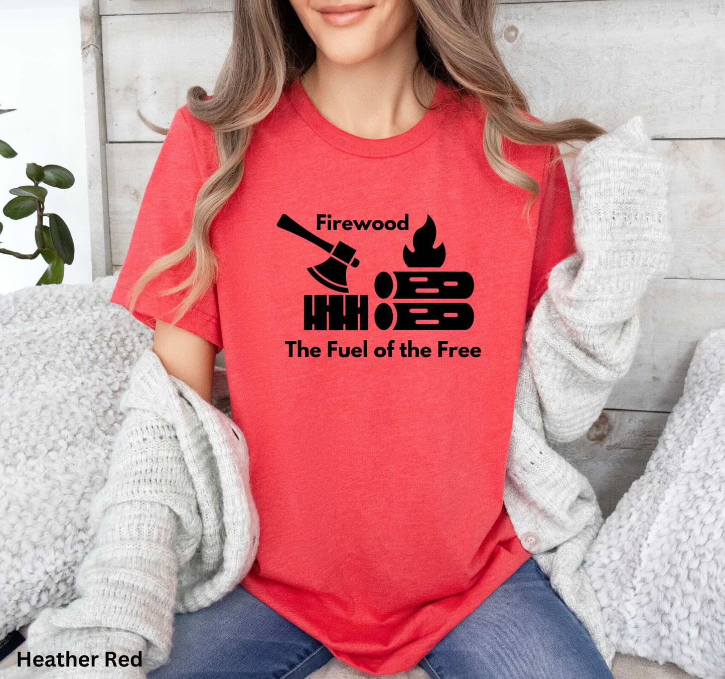 Red T-shirt with the phrase 'Firewood: The Fuel of the Free,' featuring a campfire, stacked firewood, and an ax—perfect for wood heat lovers and homesteaders.