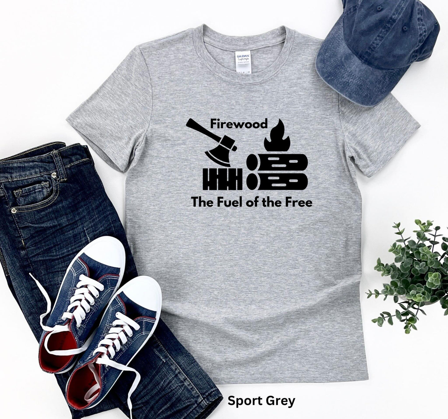 Light Grey T-shirt with the phrase 'Firewood: The Fuel of the Free,' featuring a campfire, stacked firewood, and an ax—perfect for wood heat lovers and homesteaders.