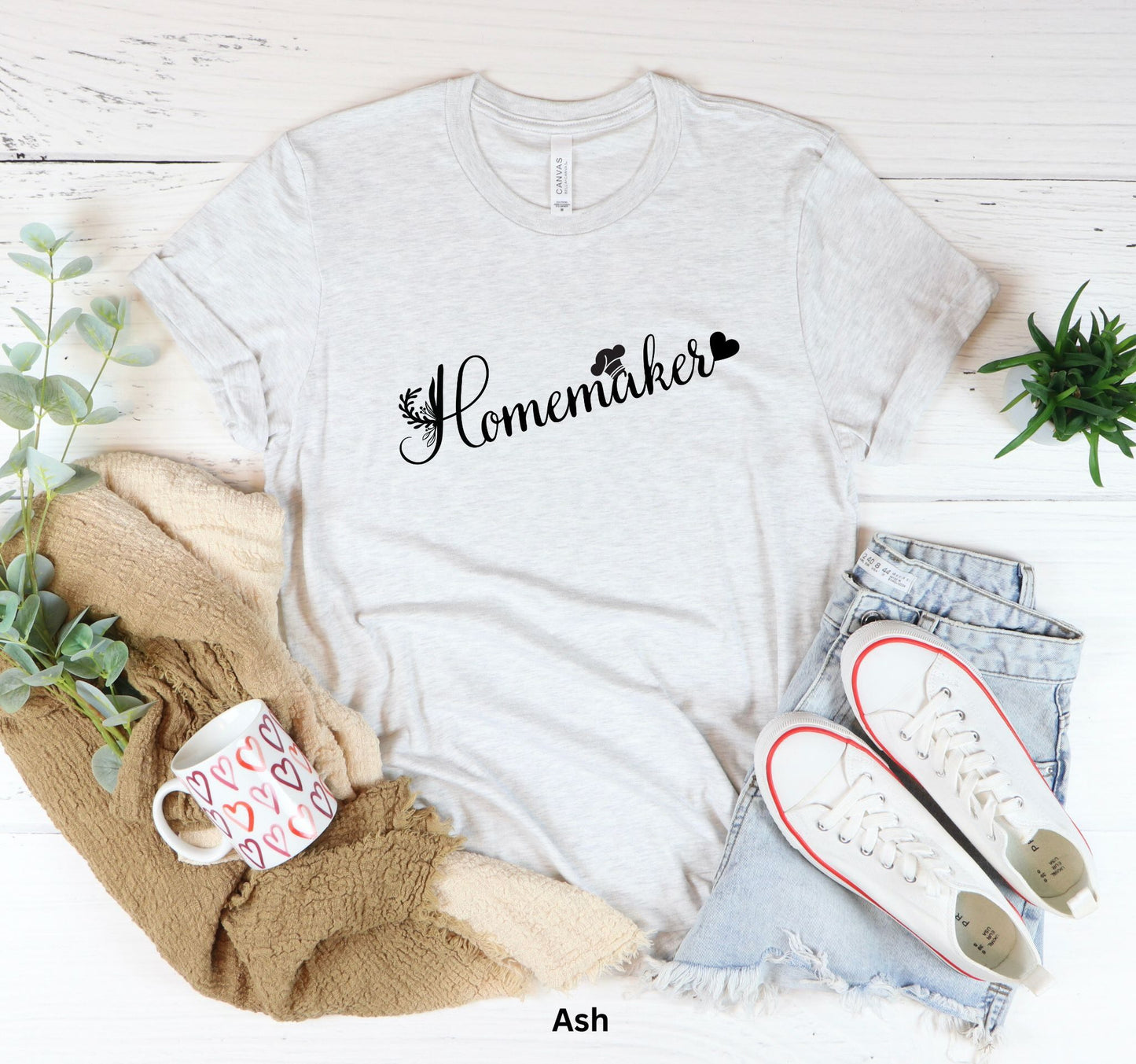 Ash colored homemaker t-shirt with floral design, chef’s hat over the 'A,' and heart accent, perfect for homesteaders, homebakers, and simple living enthusiasts.