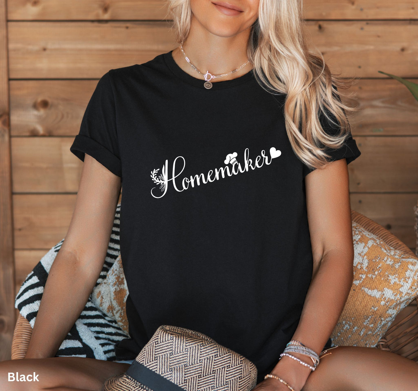 Black homemaker t-shirt with floral design, chef’s hat over the 'A,' and heart accent, perfect for homesteaders, homebakers, and simple living enthusiasts.