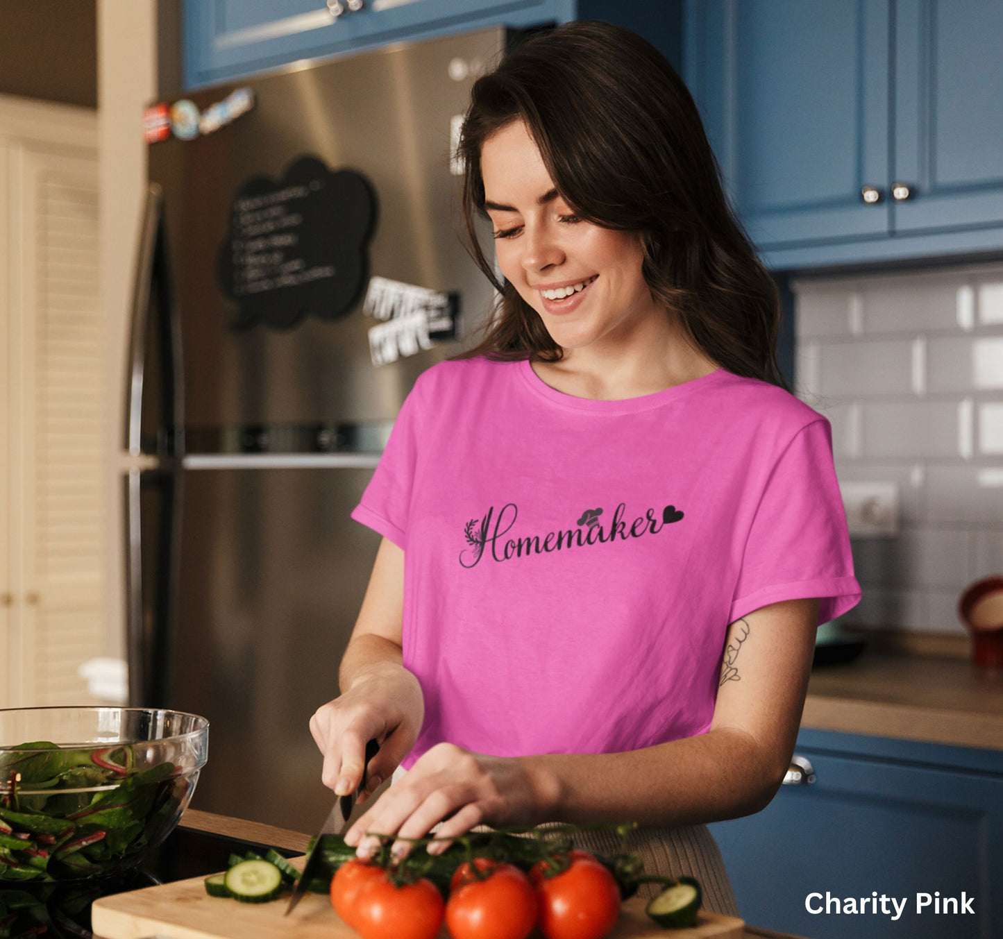 Pink homemaker t-shirt with floral design, chef’s hat over the 'A,' and heart accent, perfect for homesteaders, homebakers, and simple living enthusiasts.