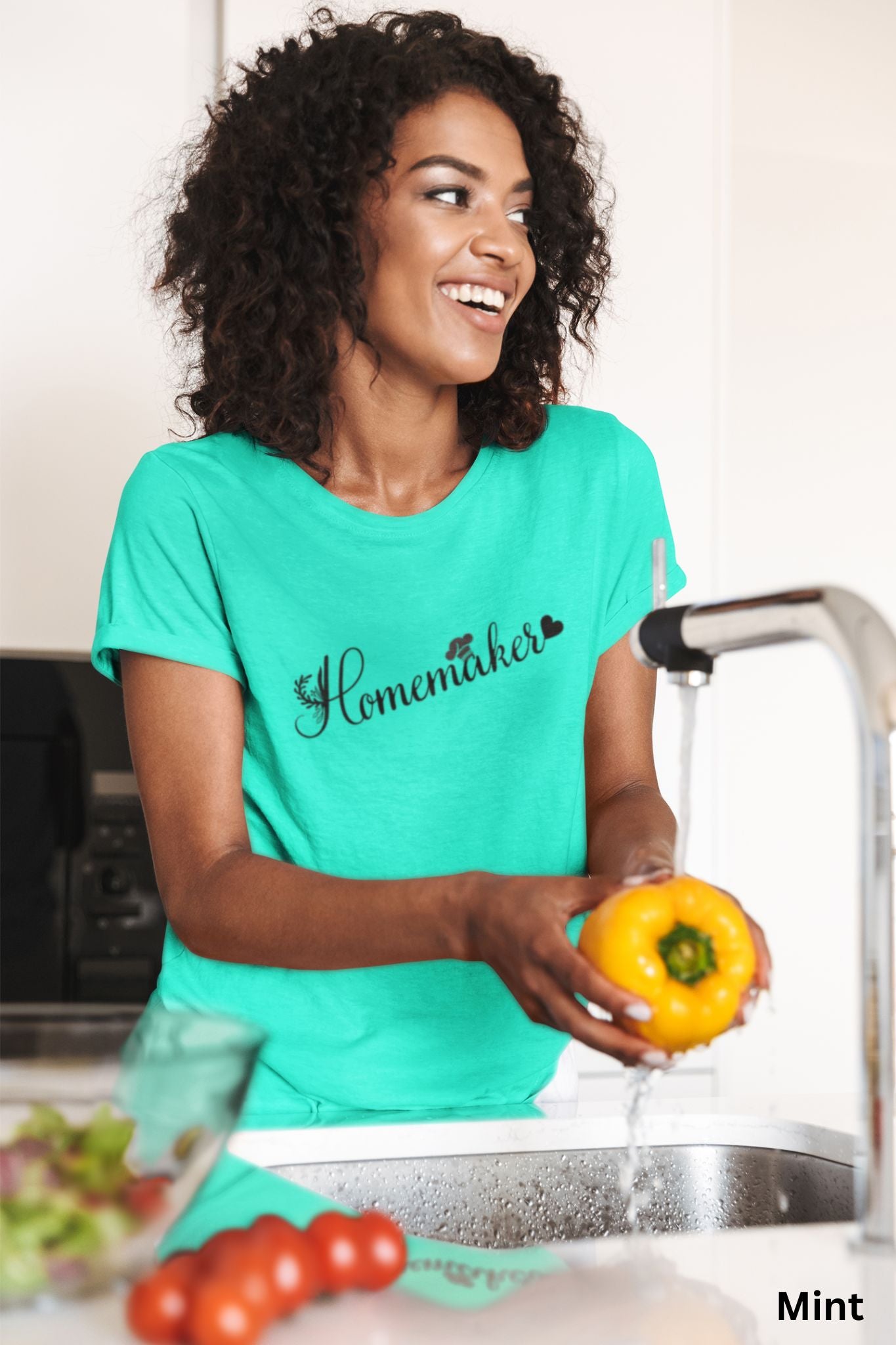 Homemaker t-shirt in mint color, with floral design, chef’s hat over the 'A,' and heart accent, perfect for homesteaders, homebakers, and simple living enthusiasts.