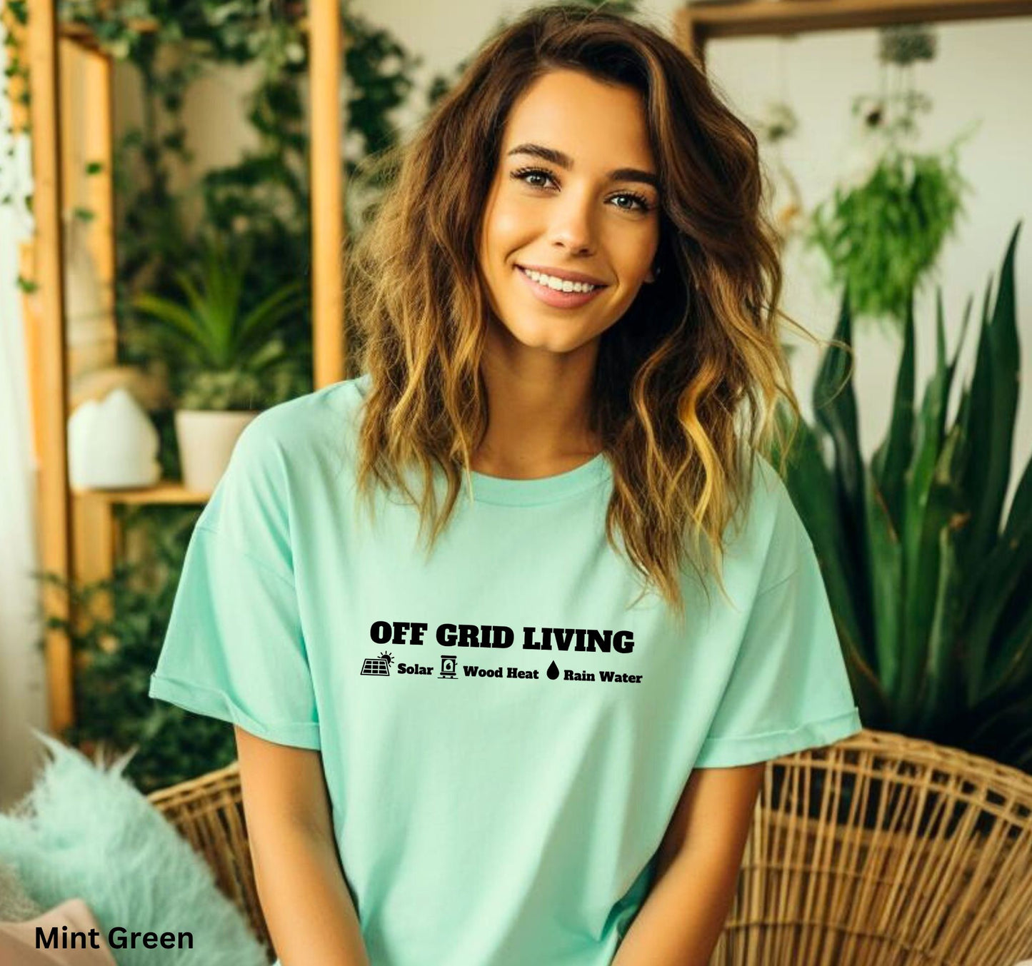 Off Grid Living t-shirt in Mint Green featuring the words 'Off Grid Living' with icons representing solar power, wood heat, and rainwater—perfect for self-sufficiency and sustainable living.