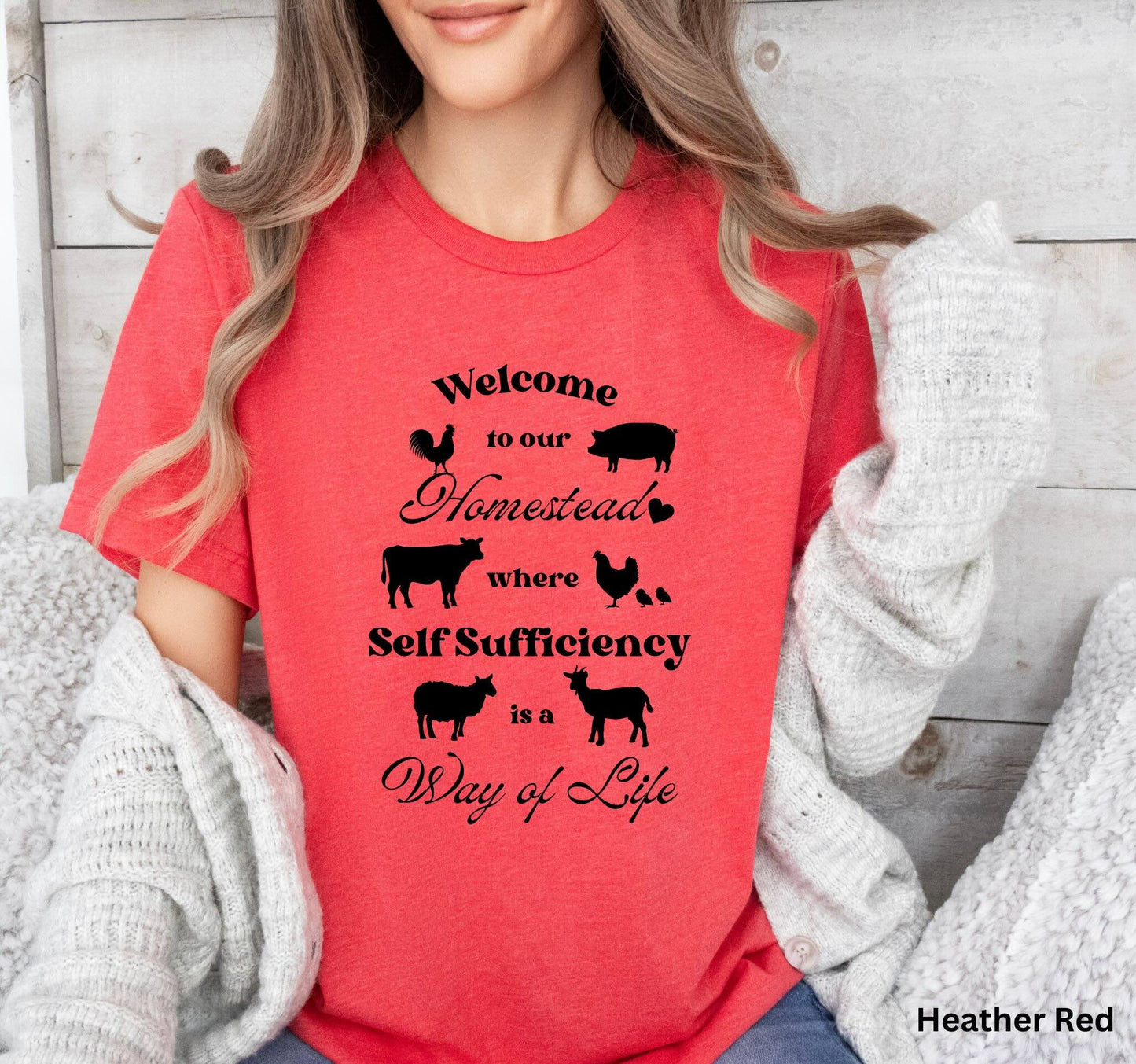 Red Homestead t-shirt featuring the phrase 'Welcome to our Homestead where Self-Sufficiency is a Way of Life' with farm animals including a rooster, hen with chicks, pig, cow, sheep, and goat. Perfect for homesteaders and farm life lovers.