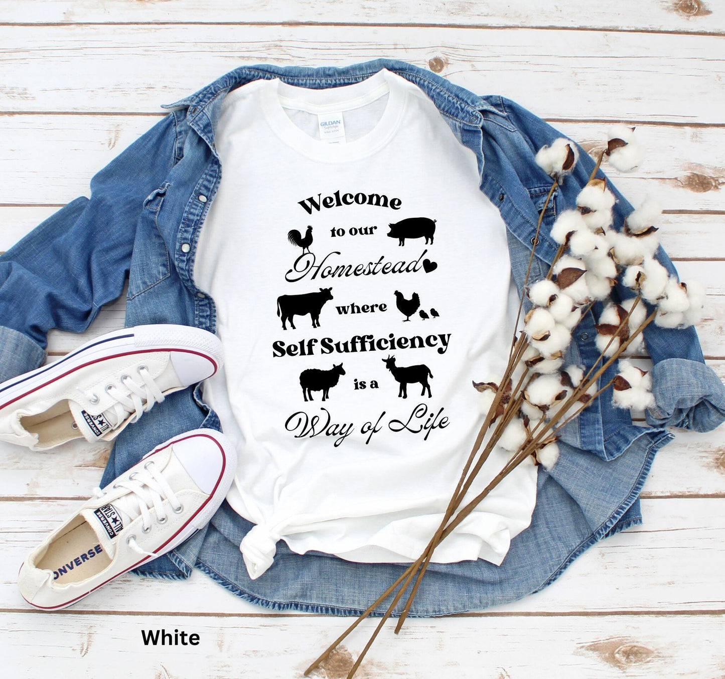 White Homestead t-shirt featuring the phrase 'Welcome to our Homestead where Self-Sufficiency is a Way of Life' with farm animals including a rooster, hen with chicks, pig, cow, sheep, and goat. Perfect for homesteaders and farm life lovers.