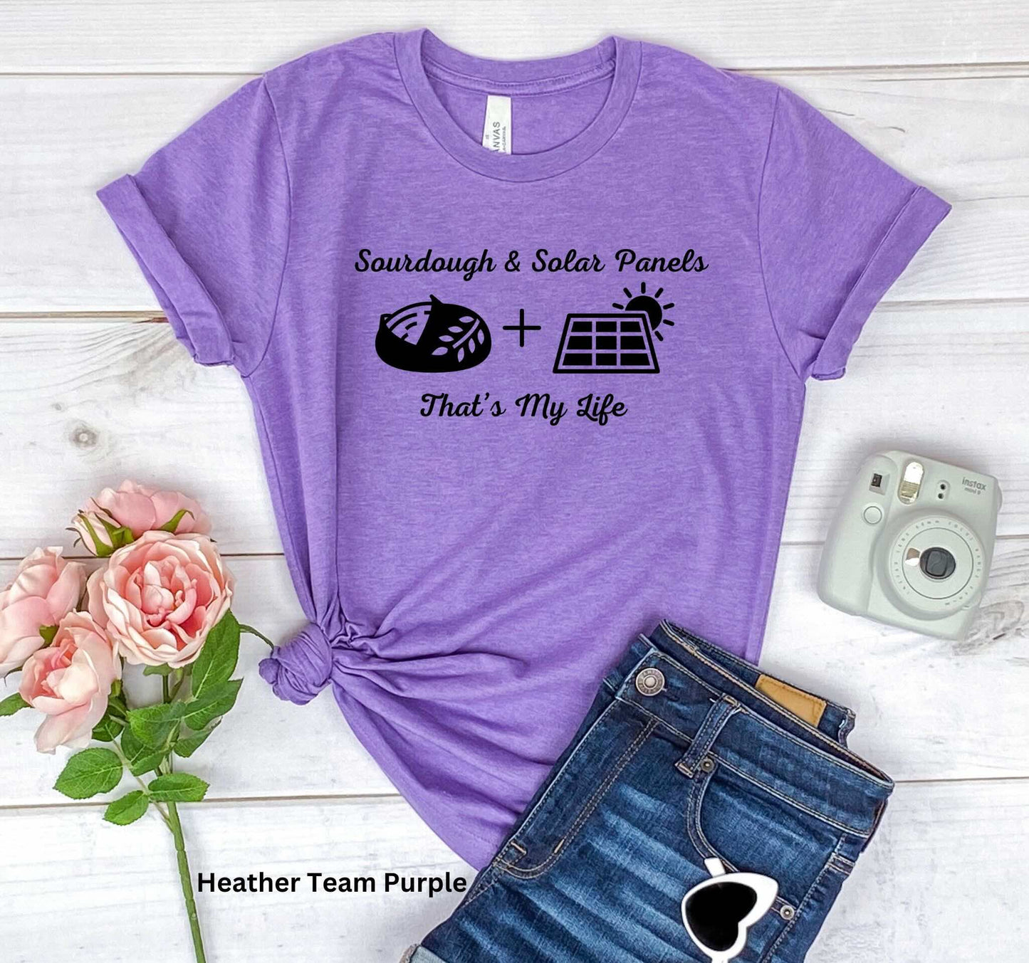 Purple T-shirt with the phrase 'Sourdough & Solar Panels, That’s My Life,' featuring a loaf of sourdough bread, a solar panel, and the sun—perfect for off-grid living.