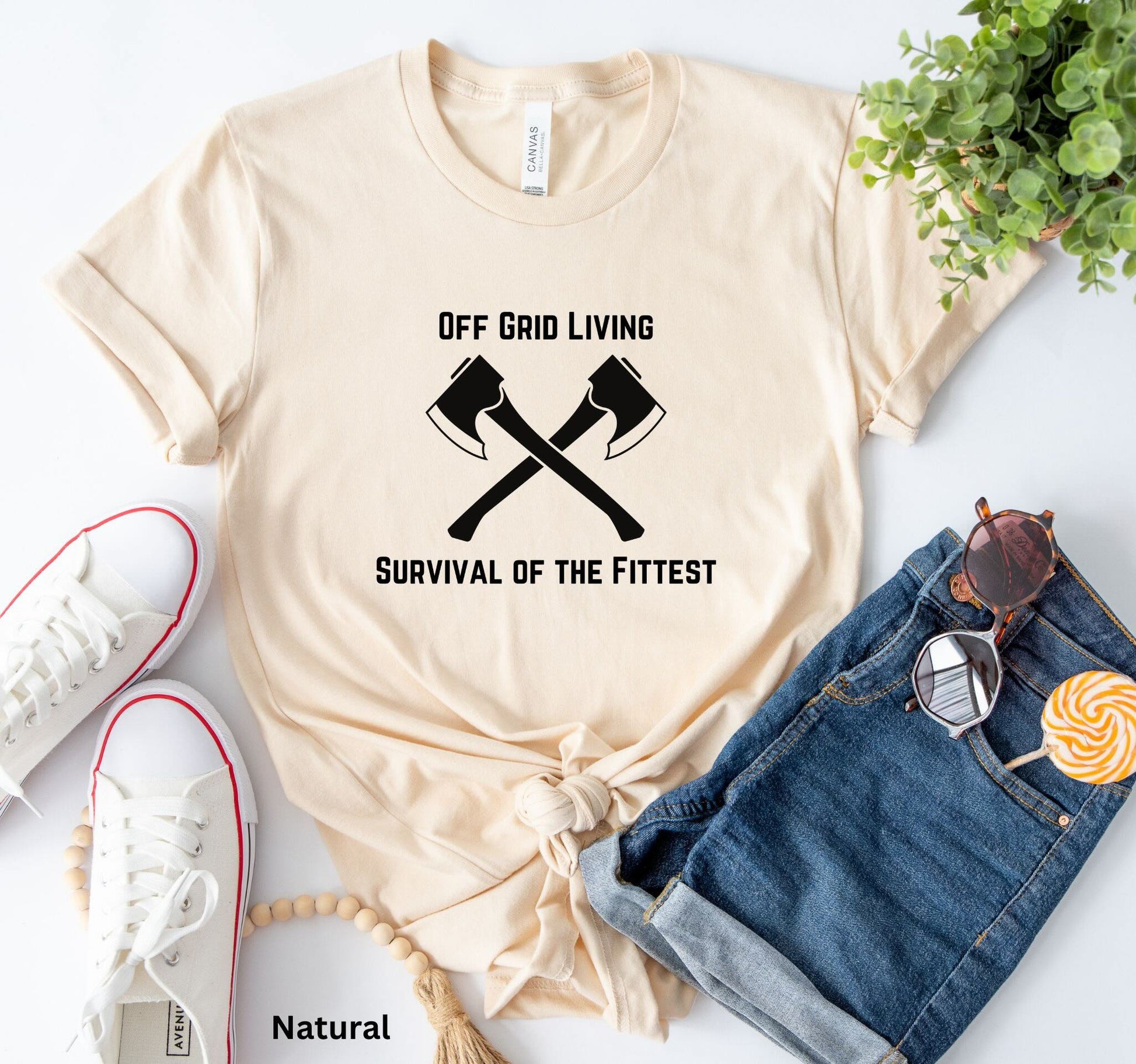 Off Grid Living t-shirt in natural color with 'Survival of the Fittest' text and crossed axes design, survivalist and bushcraft graphic tee
